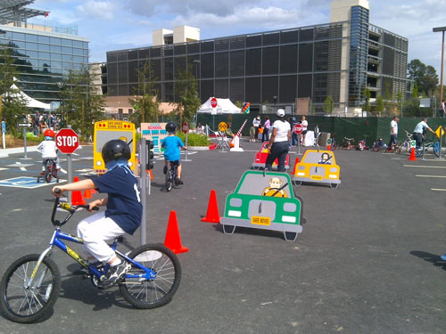 Kids biking around cones and dummy drivers